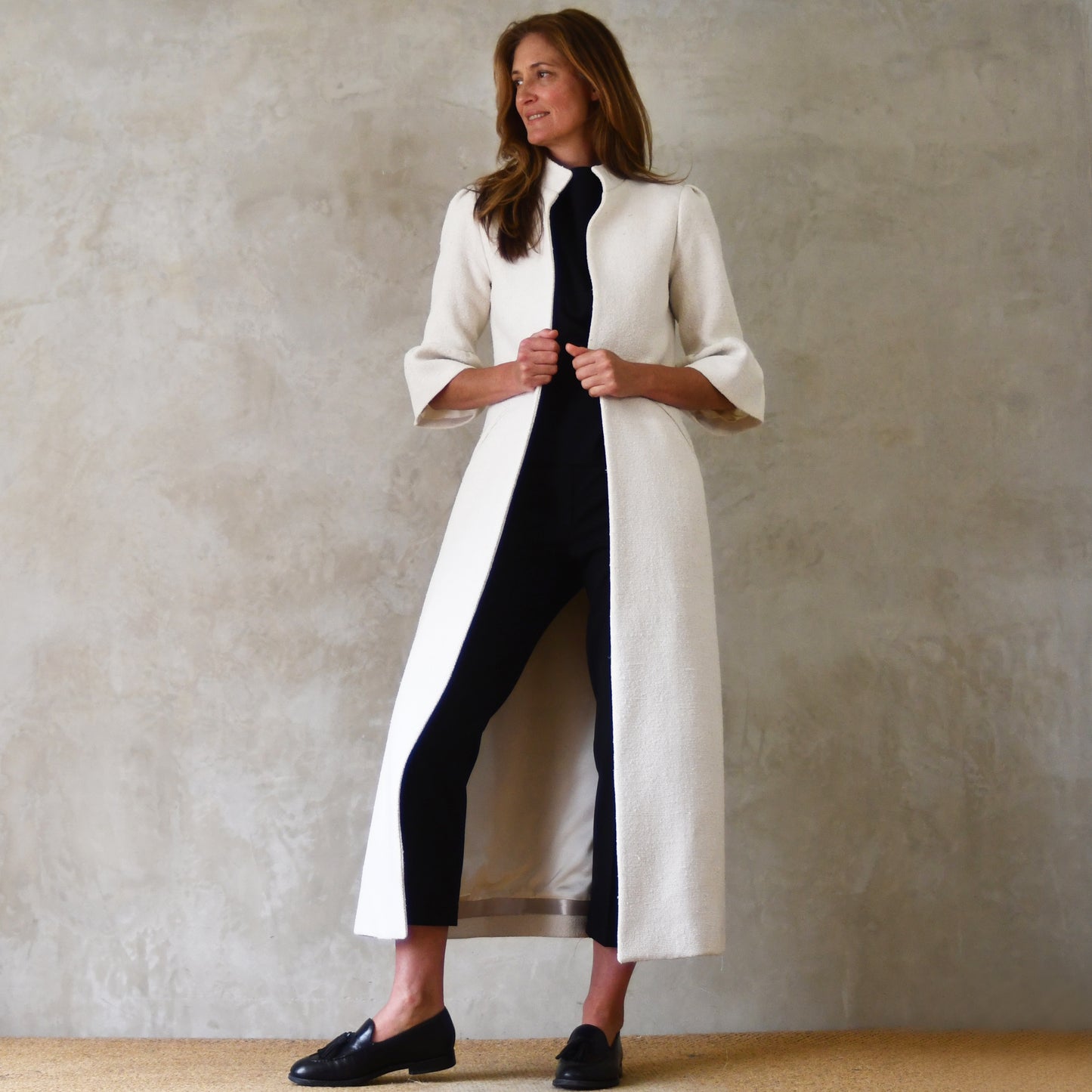 Long White Bell Sleeve Coat. This pure silk boucle is a true investment piece - perfect for white coat lovers and formal occasions. Handmade in Britain. Angled View.
