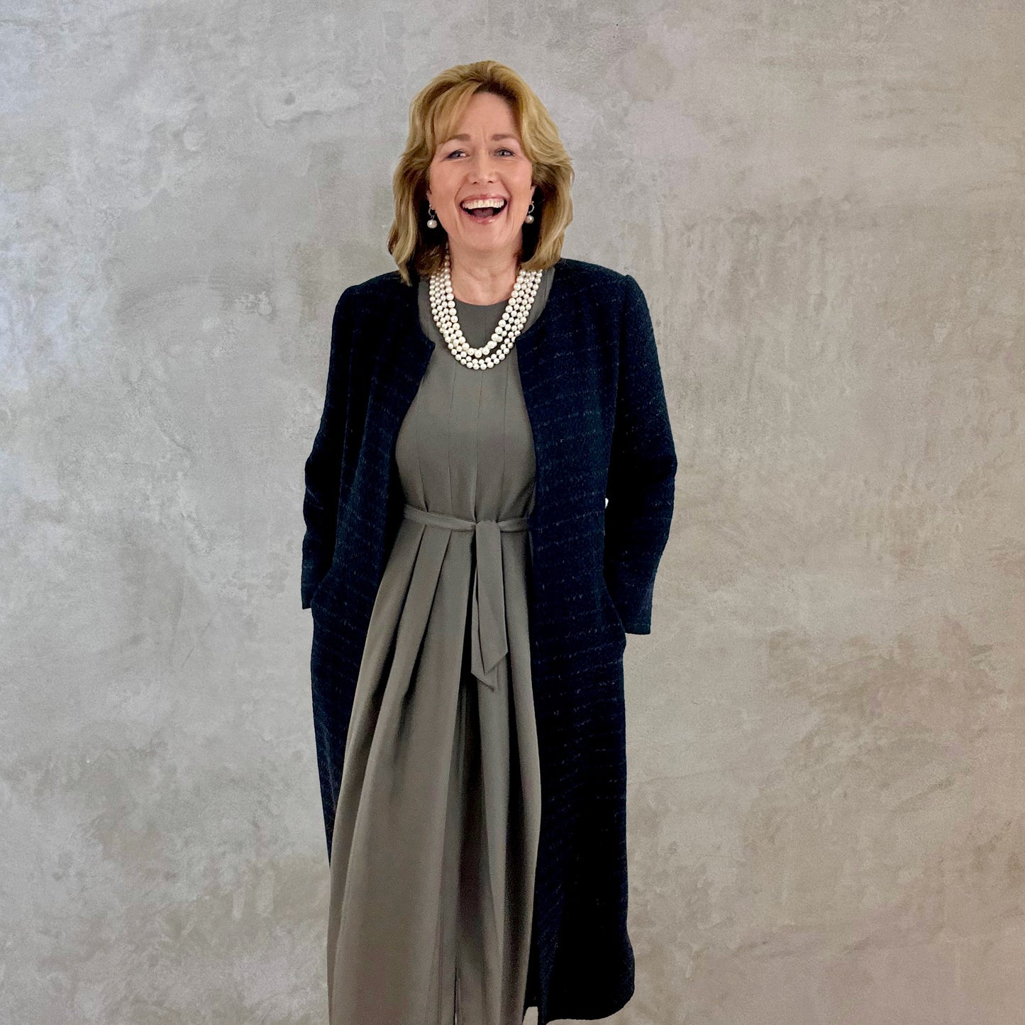 Bespoke A-Line Coat in Black Metallic Linton Tweeds Boucle. A longer length metallic boucle A-Line shaped coat with a generous swing and flattering fit. Hand cut, made and finished in London. Entirely made in Great Britain. Perfect for funerals and other formal occasions. Rear View.