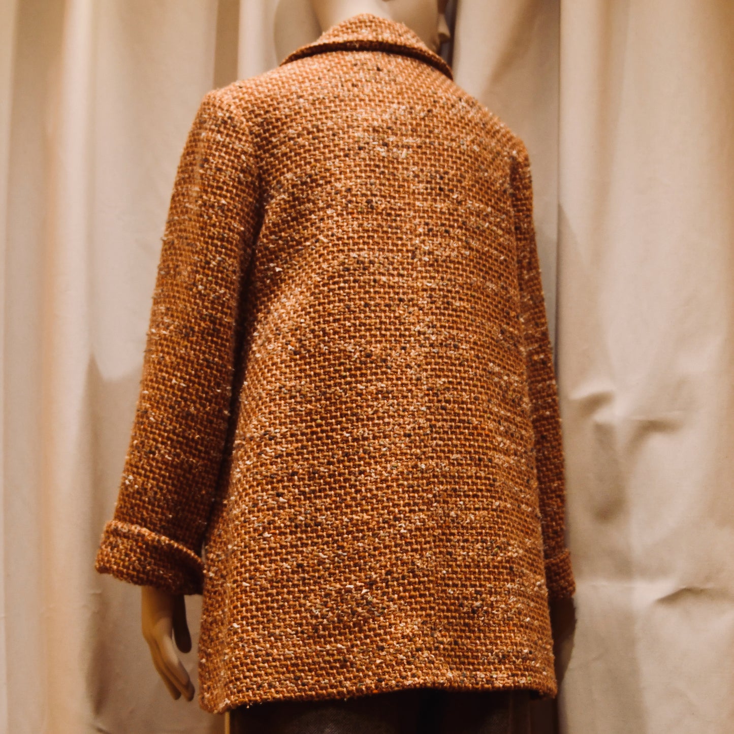 Tailored Swing Jacket in Burnt Orange Wool Mix Bouclé from Linton Tweeds. This bespoke jacket has rolled cuffs and a textured finish. Viewed from the back. Handmade in Britain.