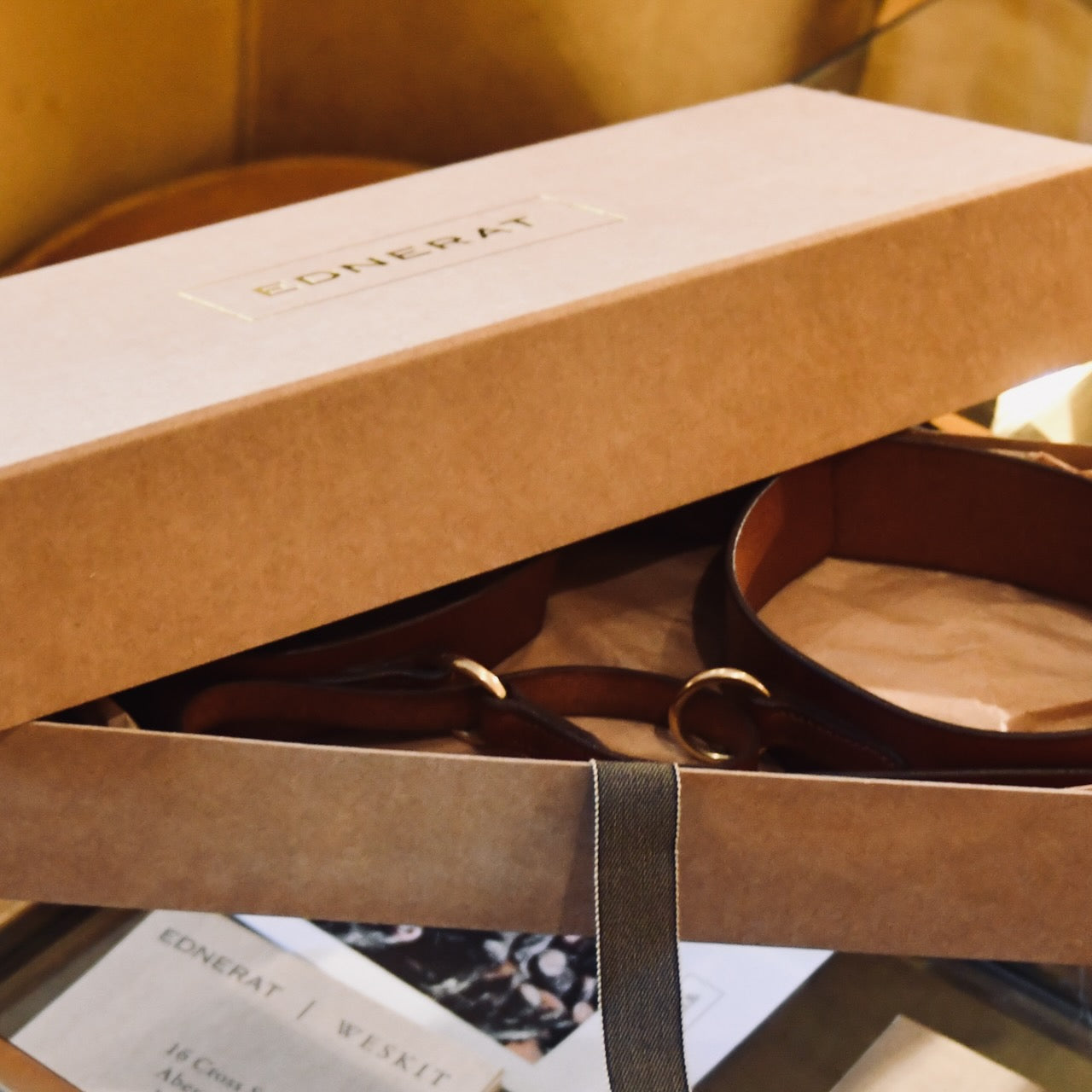 A Boxed saddle Leather Belt. The EDNERAT box reveals a Hazel Ring Wrap Belt - 68cm with solid brass fittings. Handmade in Britain.