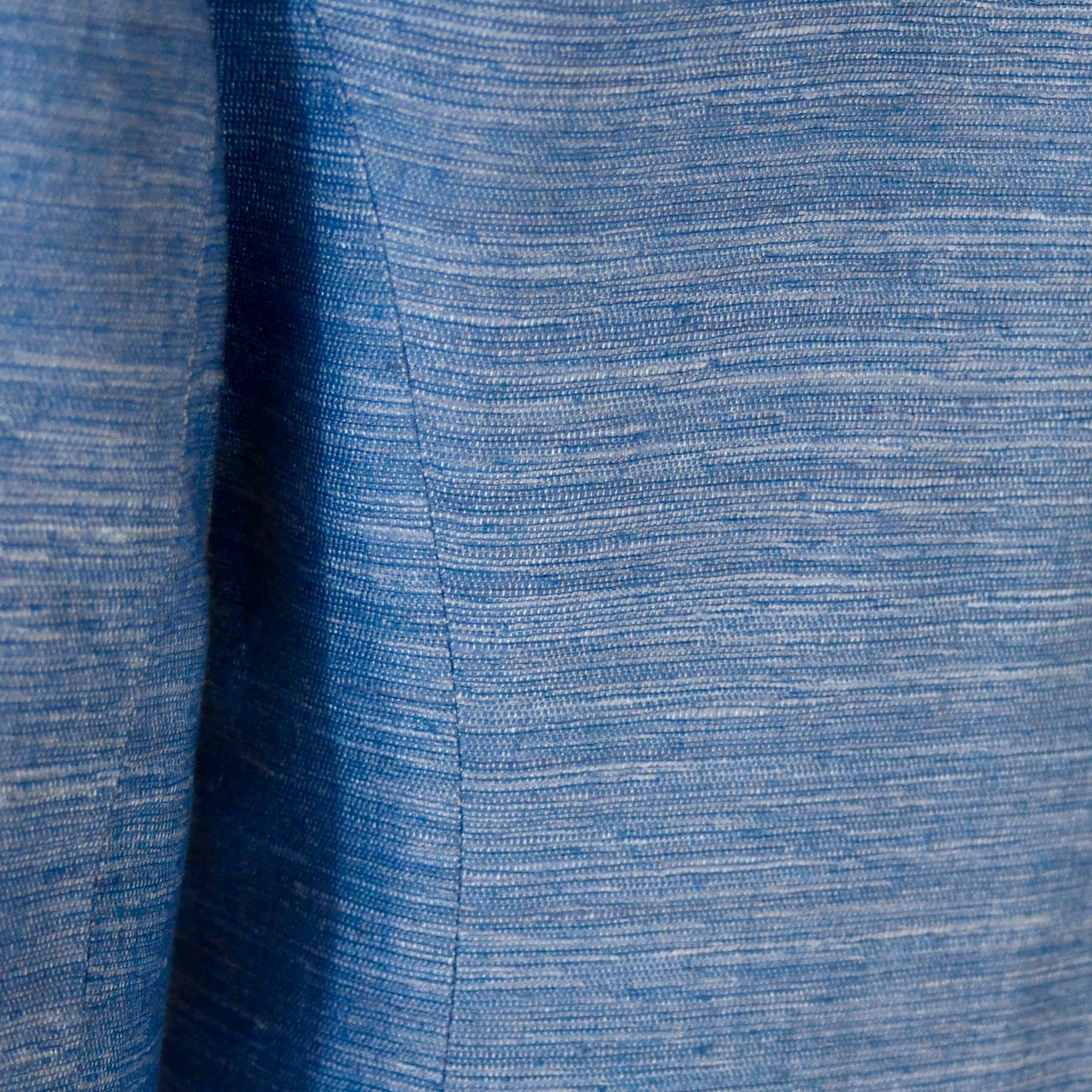 Close-up of the blue Silk Madras fabric on EdNerat Hourglass Coat Faience, highlighting visible weave patterns and a central seam—ideal for a summer coat or a tailored hourglass silhouette. Handmade in Britain.