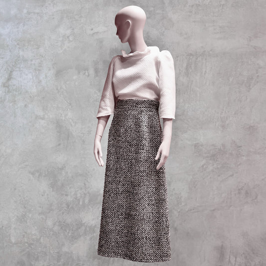 A Waisted A-Line Skirt in Linton Tweeds Boucle, styled with a textured white top. Handmade in Britain.