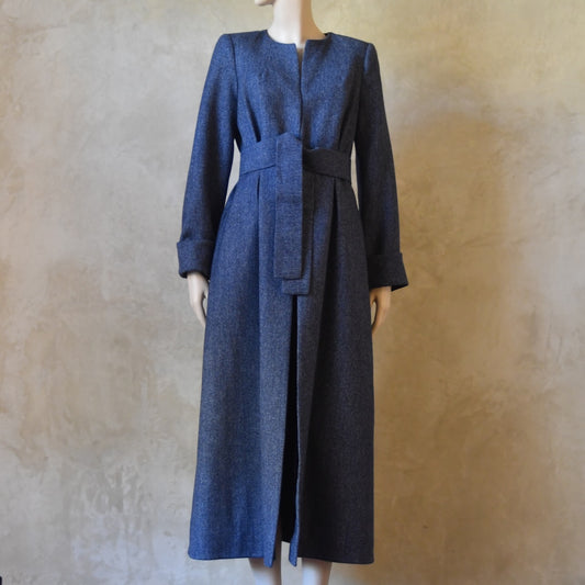 Bespoke Belted Longer Length Blue Tweed Coat, Handmade in London. Denim Blue herringbone tweed dress coat, ideal for winter weddings, race fixtures and other formalwear occasions. Fully lined in pure silk, with optional Nehru collar, fold back cuffs and self-fabric wrap around belt.