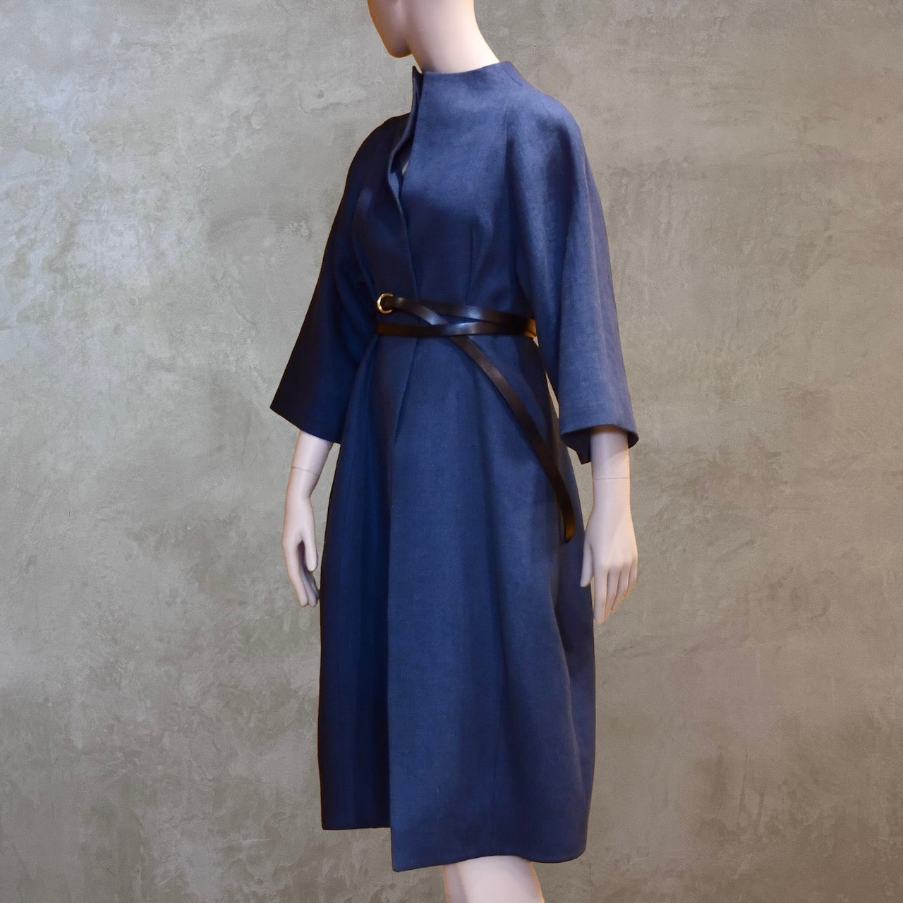 Belted Side view of Navy shorter length cocoon coat in pure irish linen. Handmade in London this coat is lined in silk, has generous shaping and can be belted at the waist.