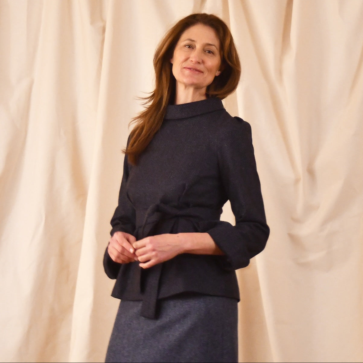 Bespoke Tailored Top in Navy Velvet—featuring long sleeves, a high rolled collar, and matching belt—paired with a blue skirt. Ideal for winter evenings. Handmade in Britain.