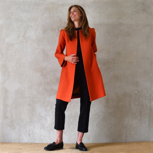 Bespoke Shoulder Detail Trapeze Coat in Burnt Orange Wool Crepe. An elegant alternative to a jacket, our mid length trapeze coat will take you to town, work, country and back. Handmade in Great Britain.