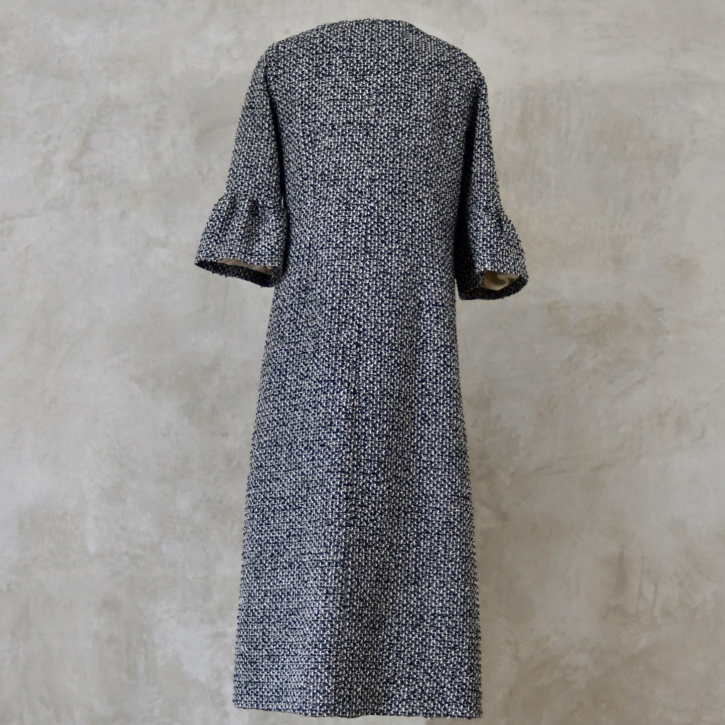 A Longer length Bell Sleeve A-Line Coat in Black and OffWhite Linton Tweeds Boucle
This is an elegant longer length A-Line coat in a patterned boucle from Carlisle. With a magnificent drape and delicate sleeve and shoulder detailing, this coat will take you everywhere. Handmade in Britain. Back View.