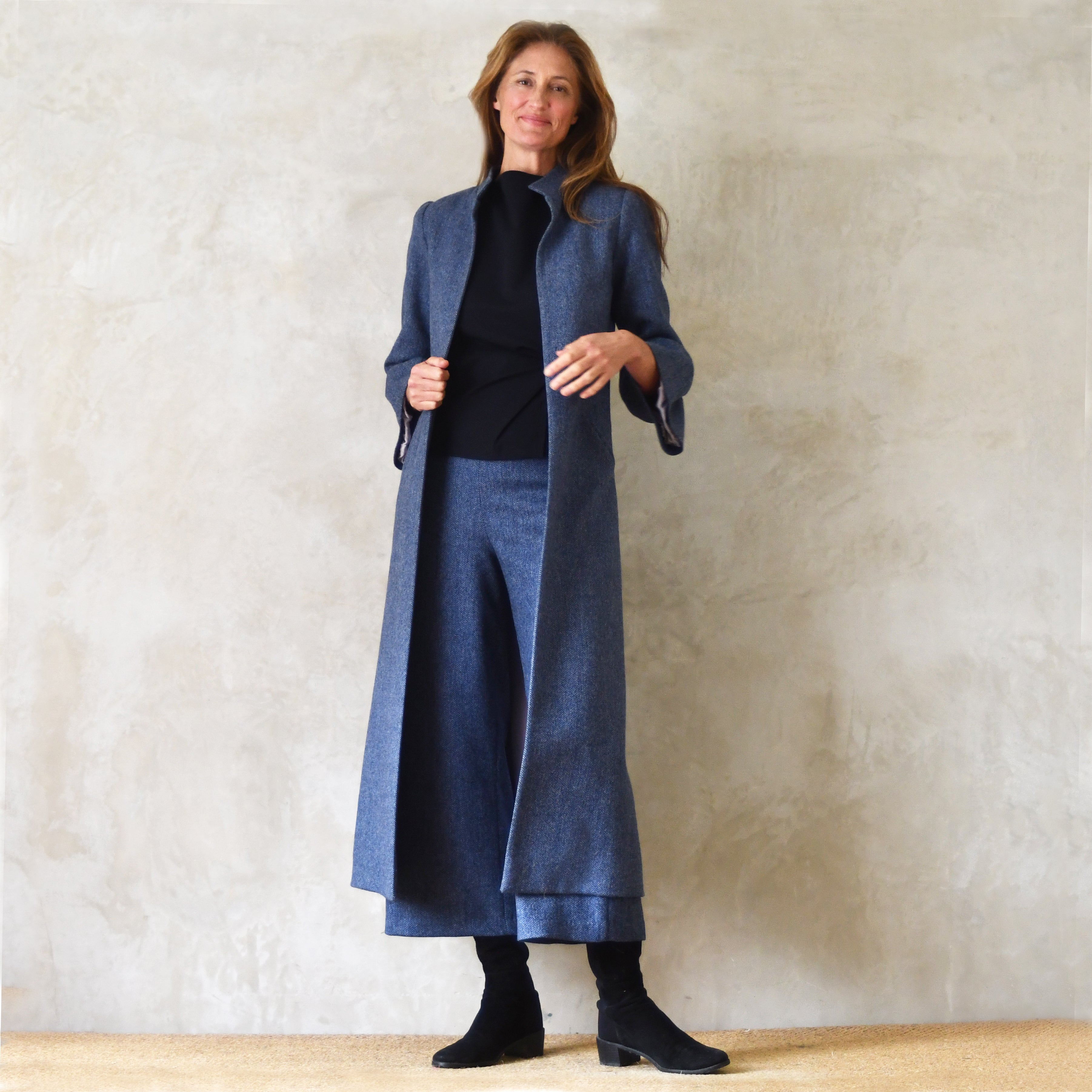 Bespoke Denim Blue Tweed Bell Sleeve A-Line Coat. Longer length A-Line Coat in Blue Herringbone Tweed. With pretty gathered cuff details on the sleeves and pleats at the shoulders, this coat is smart enough for a winter wedding and perfect for racing.
