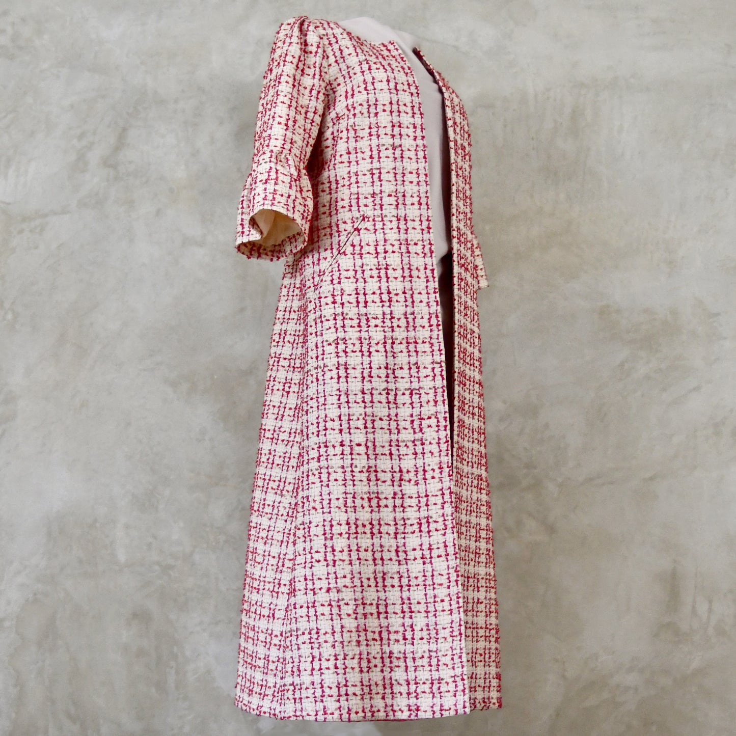 Bell Sleeve A-Line Coat in Pink Patterned Linton Tweeds Boucle. A pretty, longer length A-line coat in a pink, cream and gold check pattern for smart spring and summer occasions. Entirely made in Great Britain.