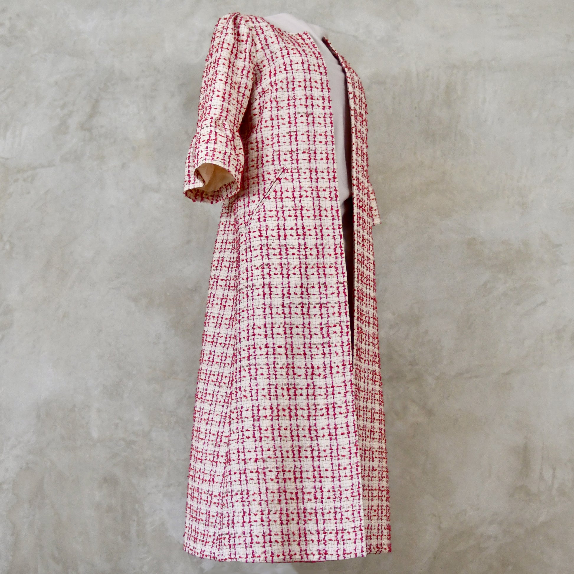 Bell Sleeve A-Line Coat in Pink Patterned Linton Tweeds Boucle. A pretty, longer length A-line coat in a pink, cream and gold check pattern for smart spring and summer occasions. Entirely made in Great Britain.