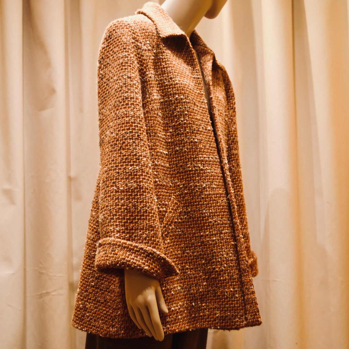 Tailored Swing Jacket in Burnt Orange Wool Mix Bouclé from Linton Tweeds. This bespoke jacket has rolled cuffs and a textured finish. Viewed Side On. Handmade in Britain.