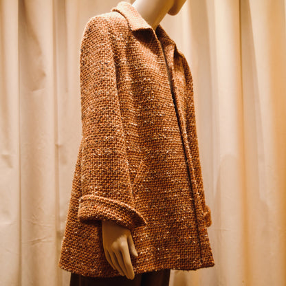 Tailored Swing Jacket in Burnt Orange Wool Mix Bouclé from Linton Tweeds. This bespoke jacket has rolled cuffs and a textured finish. Viewed Side On. Handmade in Britain.