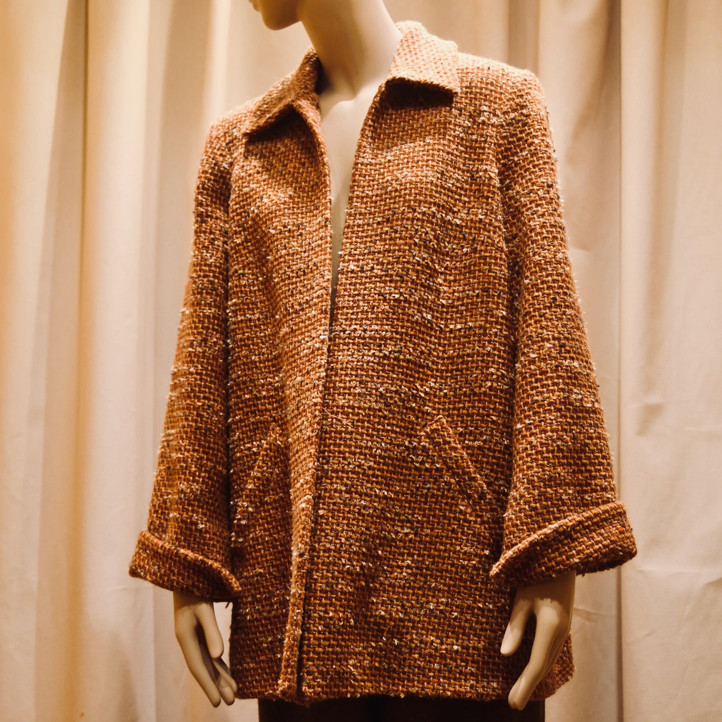 Bespoke Tailored Swing Jacket in Burnt Orange Wool Mix Bouclé from Linton Tweeds. A women’s long-sleeve, collared coat with slanted front pockets. Sophisticated and easy, the jacket is shown from the side. Handmade in Britain.