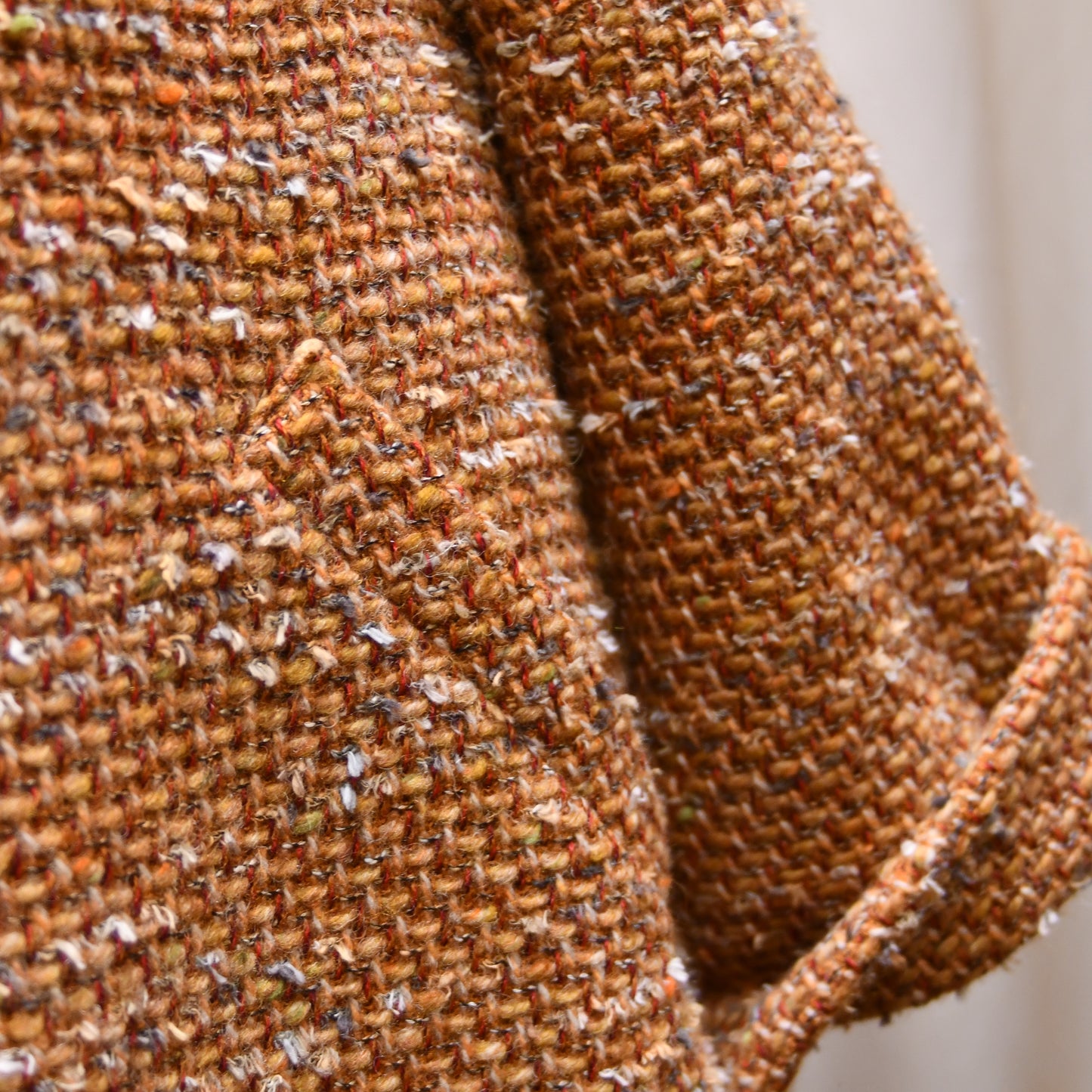 Trapeze Swing Jacket in Burnt Orange Wool Mix Bouclé from Linton Tweeds, featuring textured fabric and a side pocket. Sleeve Detail. Handmade in Britain.