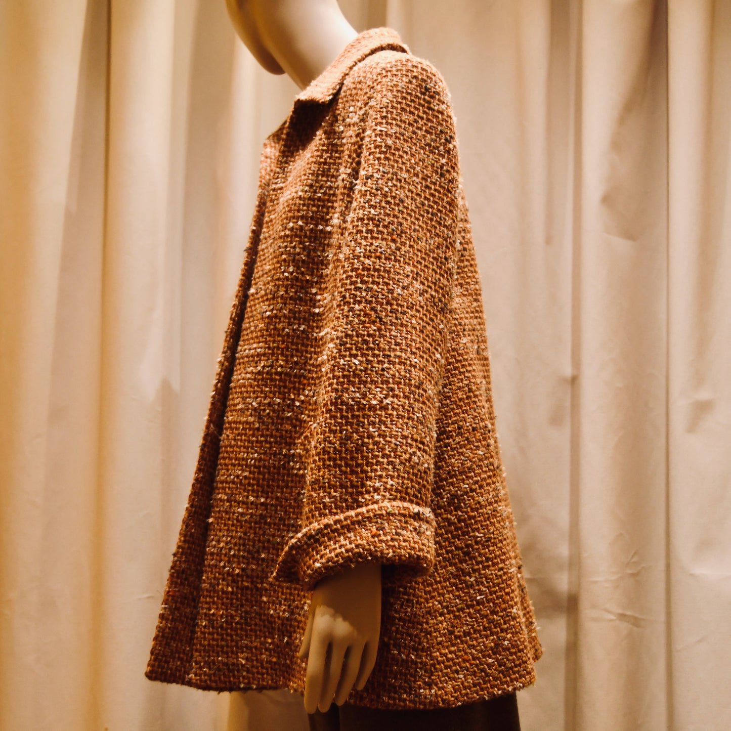 Tailored Swing Jacket in Burnt Orange Wool Mix Bouclé from Linton Tweeds. This bespoke jacket has rolled cuffs and a textured finish and a flared silhouette. Viewed from the back. Handmade in Britain.