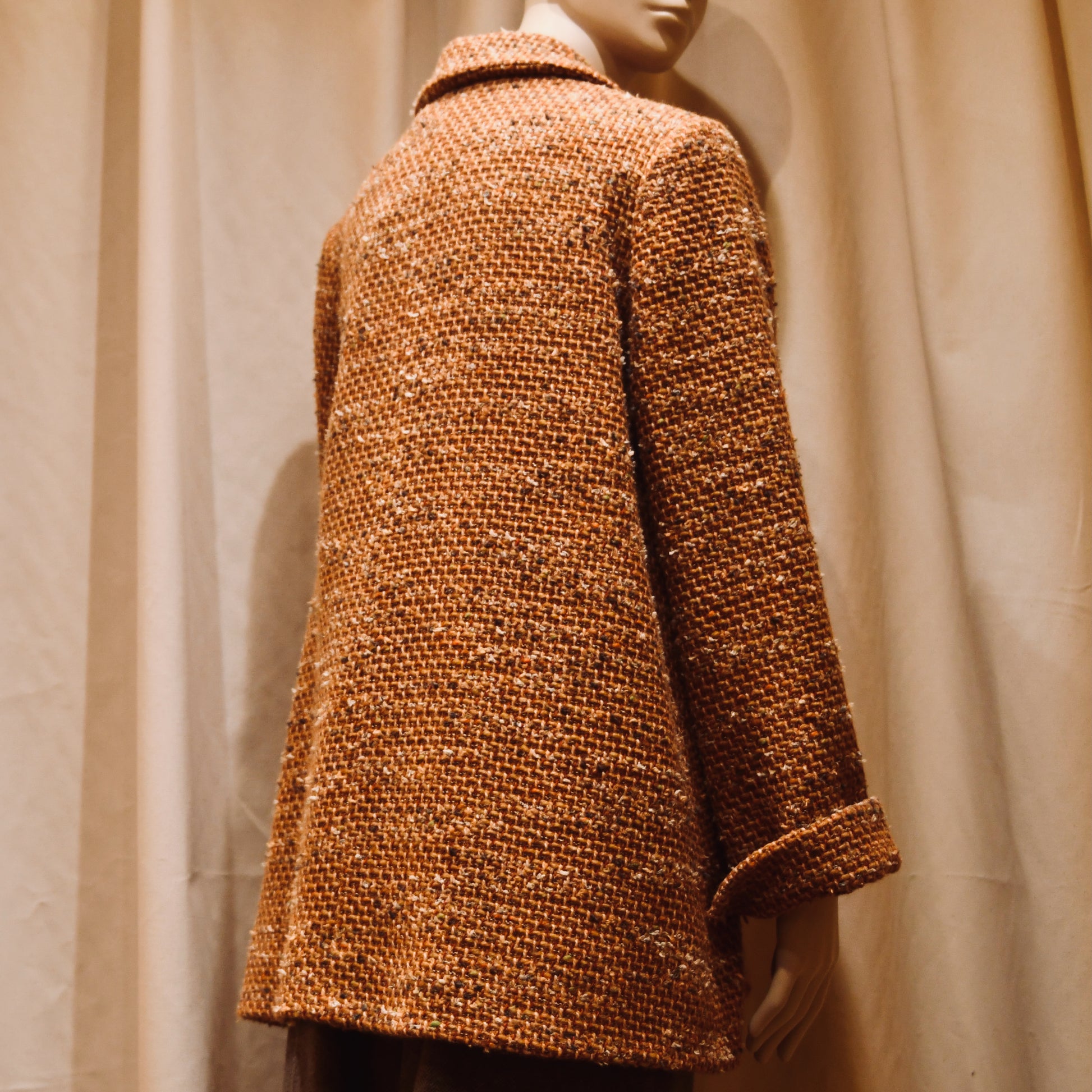Swing Jacket in Burnt Orange Wool Mix Bouclé from Linton Tweeds. Featuring a collar and turn up sleeve cuffs. Handmade in Britain. Turned View.