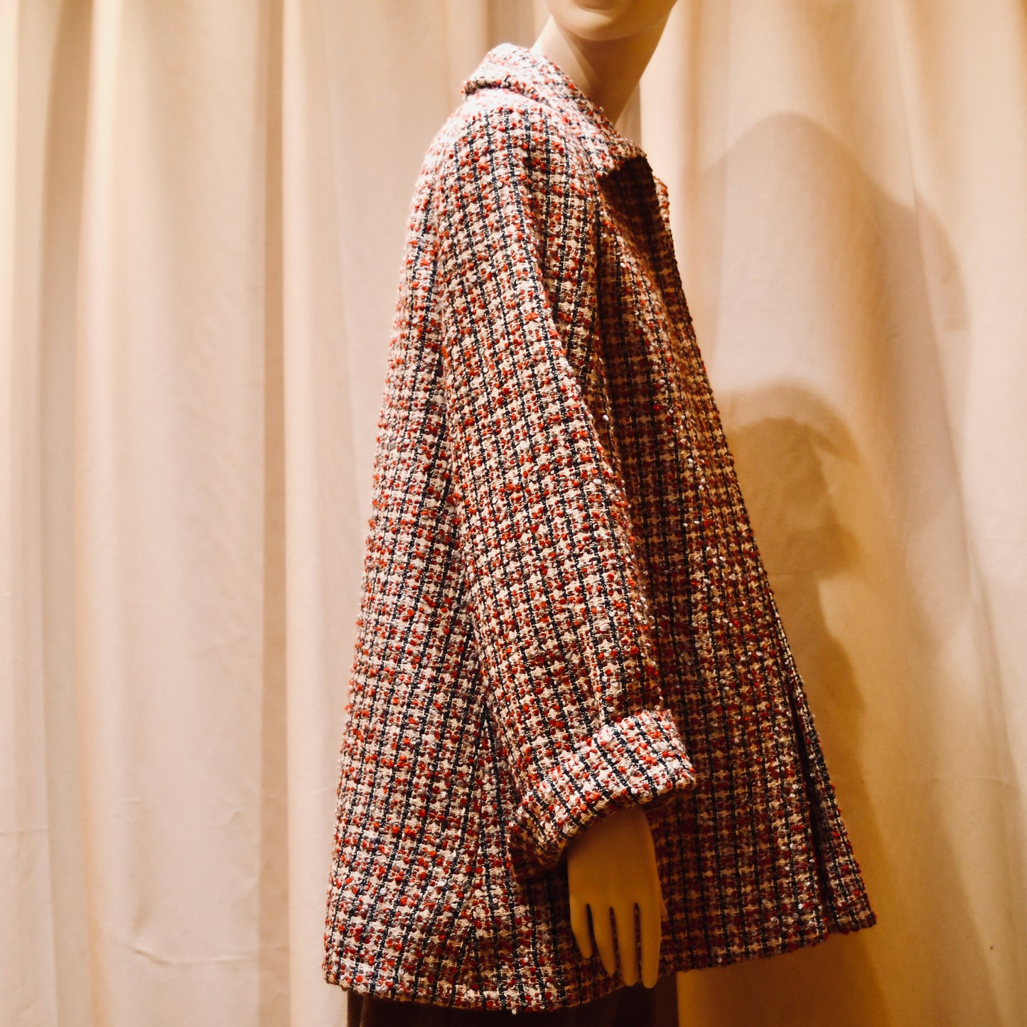 Tailored Swing Jacket in in Red, Ecru and Navy Wool Bouclé from Linton Tweeds. This bespoke jacket has rolled cuffs, a textured finish and a flared silhouette. Shown from  the side. Handmade in Britain.