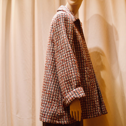 Tailored Swing Jacket in in Red, Ecru and Navy Wool Bouclé from Linton Tweeds. This bespoke jacket has rolled cuffs, a textured finish and a flared silhouette. Shown from  the side. Handmade in Britain.