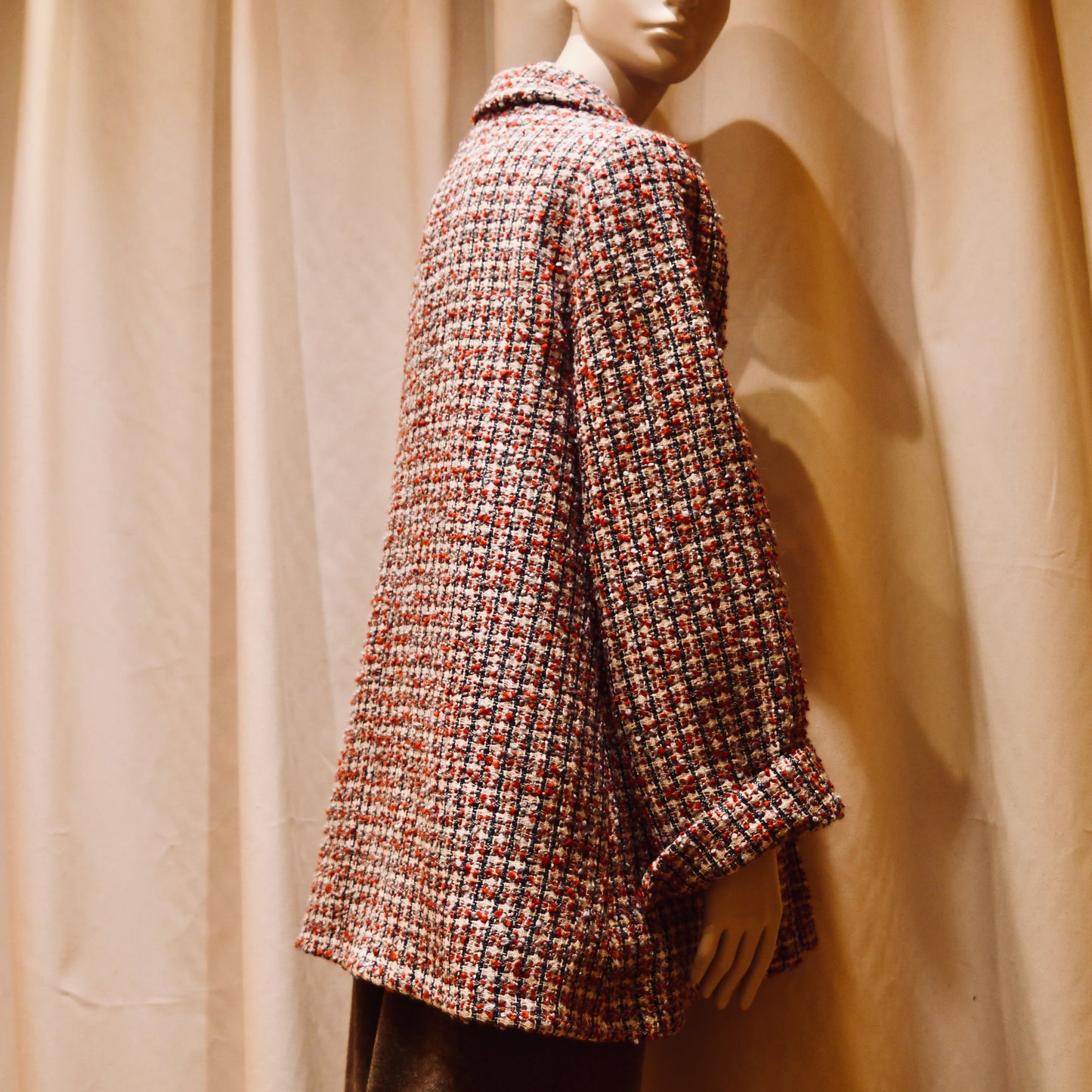 Trapeze Swing Jacket in red, ecru, and navy Wool Bouclé from Linton Tweeds. With long sleeves and a collar,  it is shown viewed from the side. Handmade in Britain.