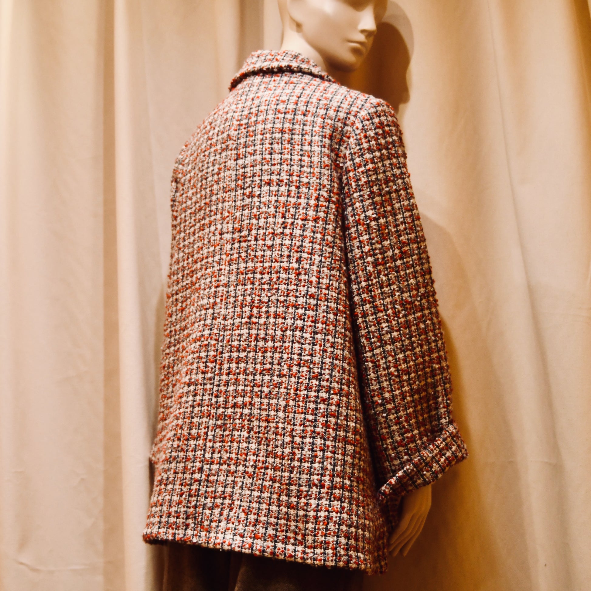 A Swing Trapeze Jacket in Red, Ecru and Navy Wool Mix Bouclé, from Linton Tweeds. Shown from the back.   featuring a collar, textured finish, and multicolored design, Handmade in Britain.