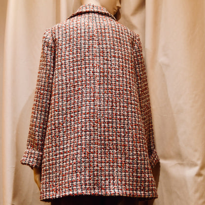 Bespoke Trapeze Swing Jacket in red, ecru, and navy Wool Bouclé from Linton Tweeds. With long sleeves and a collar,  it is shown viewed from the back. Handmade in Britain.
