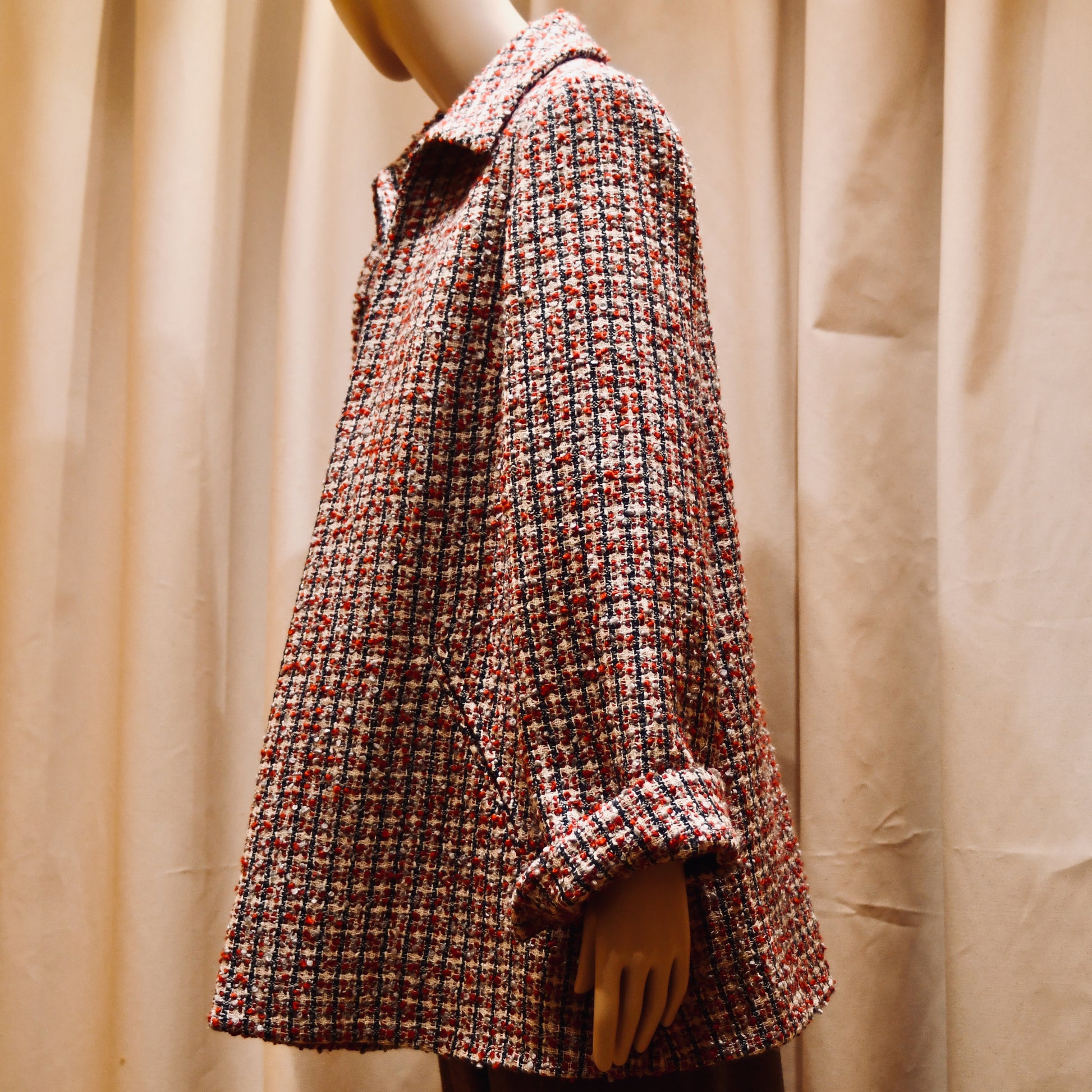 Tailored Swing Jacket in in Red, Ecru and Navy Wool Bouclé from Linton Tweeds. This bespoke jacket has rolled cuffs, a textured finish and a flared silhouette. Shown from side. Handmade in Britain.
