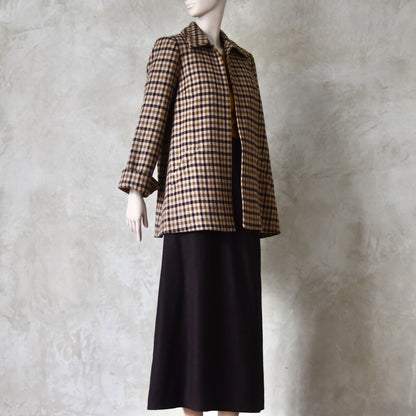 Full length view of Swing jacket in pure merino wool. An easy to wear mid length jacket with pockets and a generous collar in Fox Brothers gunclub check flannel. A generous pure merino flannel this is the softest fabric you will touch and will last for eons. Handmade in London. Shown worn over a longer length pure merino flannel skirt in chocolate.