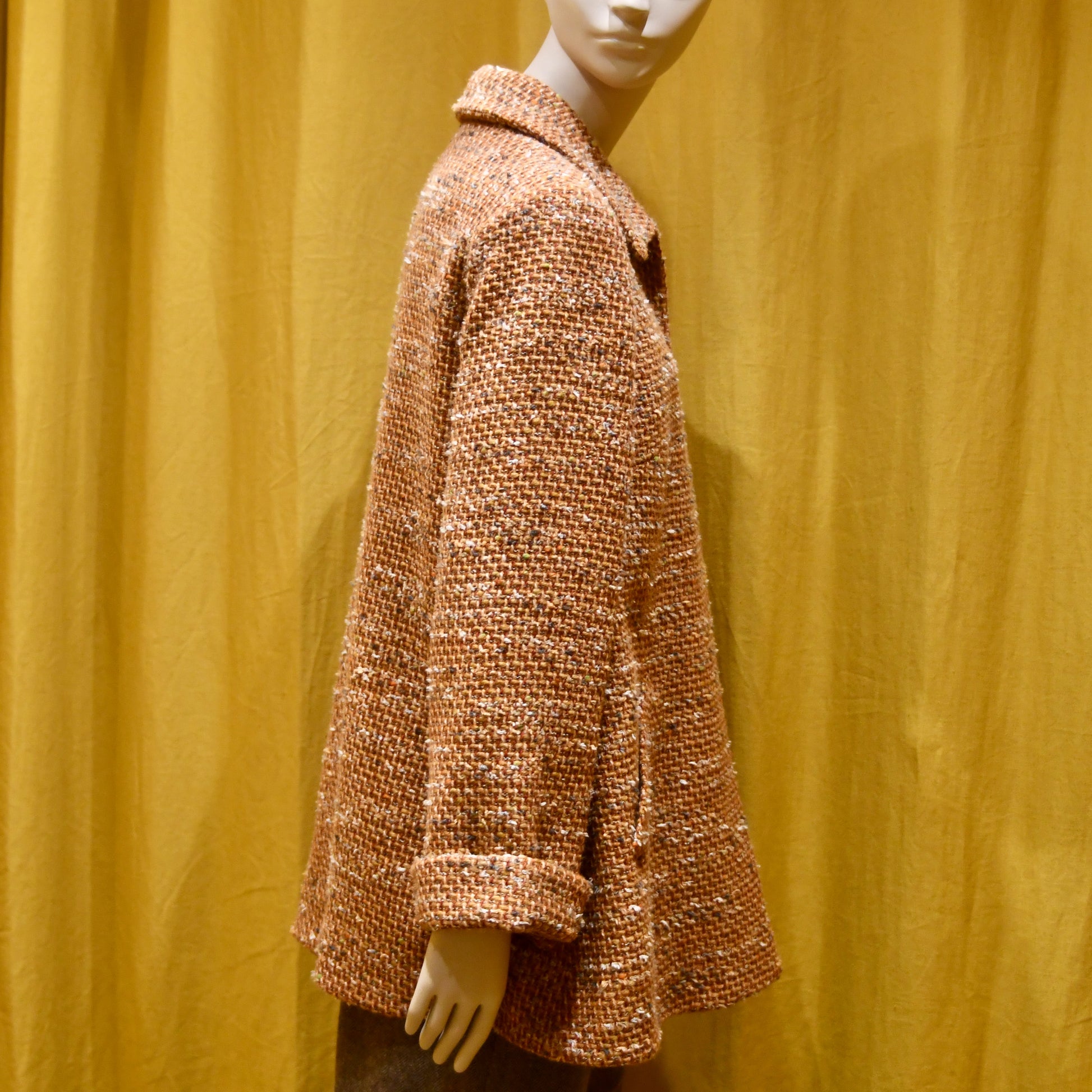 Trapeze Swing Jacket in Burnt Orange Wool Mix Bouclé from Linton Tweeds, featuring textured fabric and a side pocket. Side View. Handmade in Britain.
