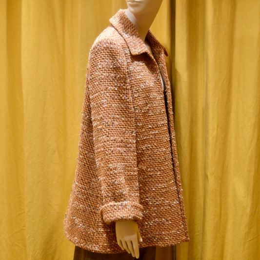 Tailored Swing Jacket in Burnt Orange Wool Mix Bouclé from Linton Tweeds. This bespoke jacket has rolled cuffs and a textured finish and a flared silhouette. Shown side on. Handmade in Britain.