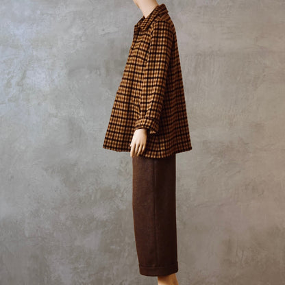 Tailored Swing Jacket in Fox Flannel Brown Gunclub Check, in pure merino wool. This bespoke jacket has rolled cuffs and a textured finish and a flared silhouette. Shown side on. Handmade in Britain.