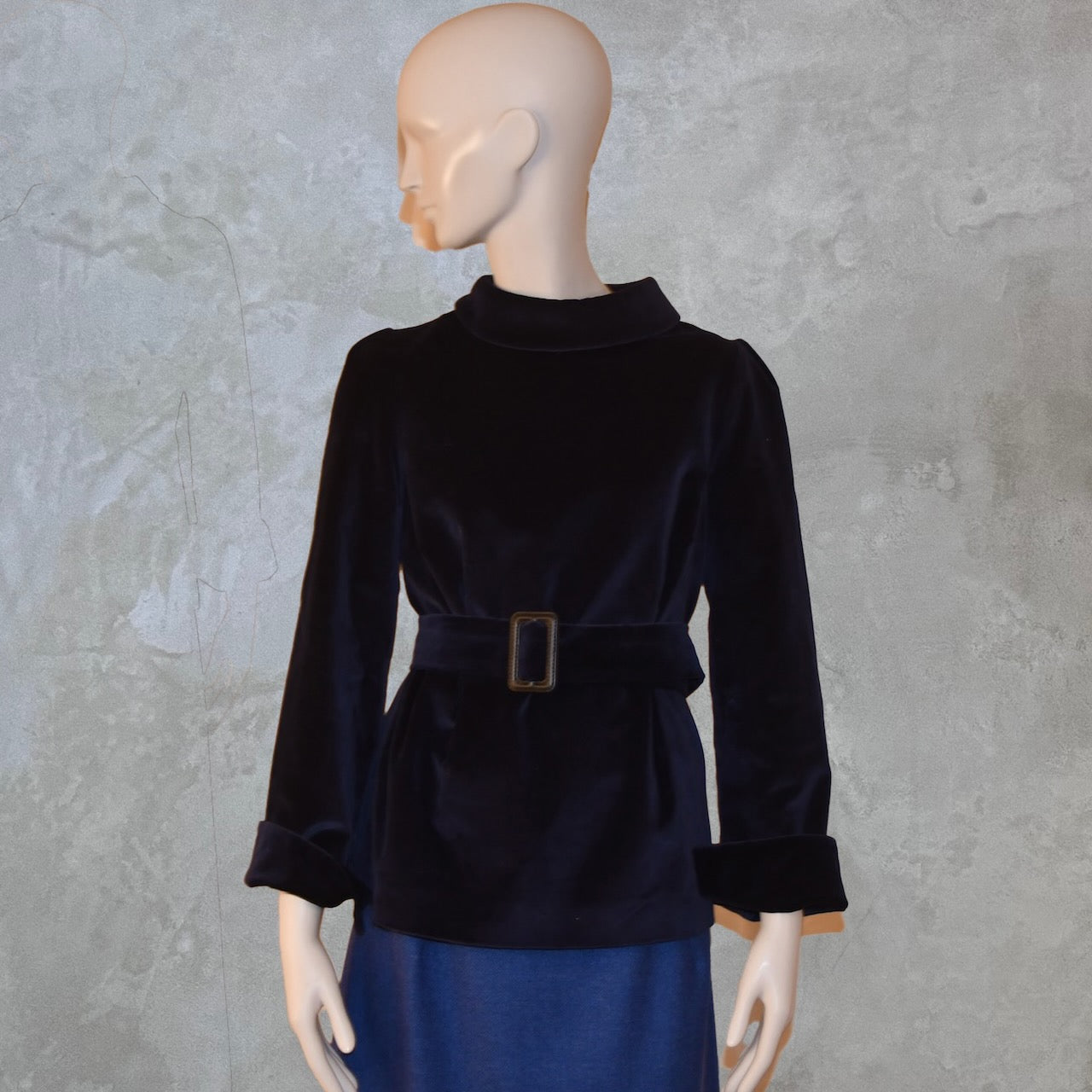 A Tailored Top in Navy Velvet—featuring long sleeves, a high rolled collar, and matching belt—paired with a blue skirt. Ideal for winter evenings. Handmade in Britain.