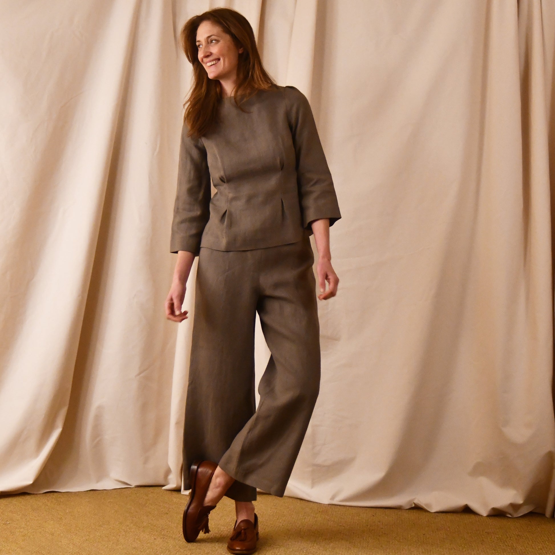 A Tailored Boat Neck Blouse in Brown Irish Linen. Fitted and elegant the top is shown over a matching loose fitting Linen Pants. Handmade in Britain.