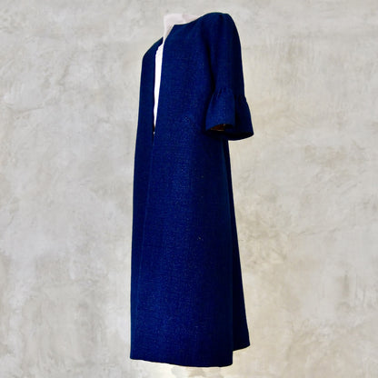 A Bespoke Bell Sleeved A Line Coat in Navy, Black and White Cotton Boucle from Linton Tweeds. A minimalist but elegant summer coat with three-quarter bell sleeves and an A-Line design. Handmade in Britain. 
