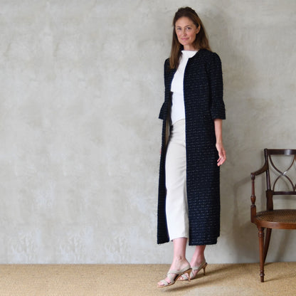 A Bespoke Bell Sleeved A Line Coat in Navy, Black and White Cotton Boucle from Linton Tweeds. A minimalist but elegant summer coat with three-quarter bell sleeves and an A-Line design. Handmade in Britain. 