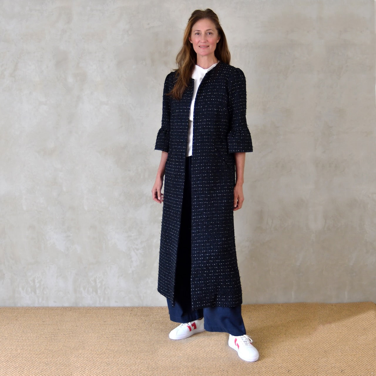 A Bespoke Bell Sleeved A Line Coat in Navy, Black and White Cotton Boucle from Linton Tweeds. A minimalist but elegant summer coat with three-quarter bell sleeves and an A-Line design. Handmade in Britain. 
