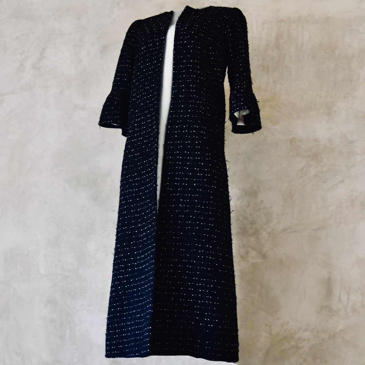 A Bespoke Bell Sleeved A Line Coat in Navy, Black and White Cotton Boucle from Linton Tweeds. A minimalist but elegant summer coat with three-quarter bell sleeves and an A-Line design. Handmade in Britain. 