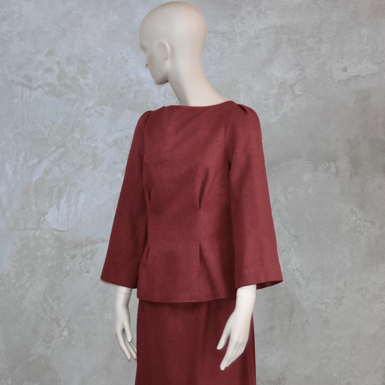 A Bespoke Tailored Boat Neck Blouse in Dark Pink Silk Matka with a matching skirt, posed sideways. Handmade in Britain.