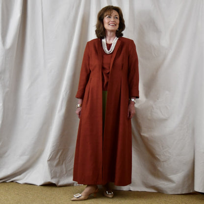 Fitted Occasion Coat in Summer Weight Silk Matka. A terracotta-coloured woven silk, falls gracefully from two front and rear dart details. Handmade in Britain.