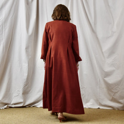 Fitted Occasion Coat in Summer Weight Silk Matka. A terracotta-coloured woven silk, falls gracefully from two front and rear dart details. Handmade in Britain. Rear View.