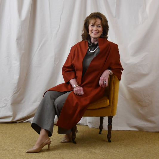 Summer Weight Cocoon Coat in Terracotta Silk. A Bespoke Silk Matka Cocoon Shaped Coat with under-bust and rear gathers, creating a shapely silhoutte.
Handmade in Britain. Seated.