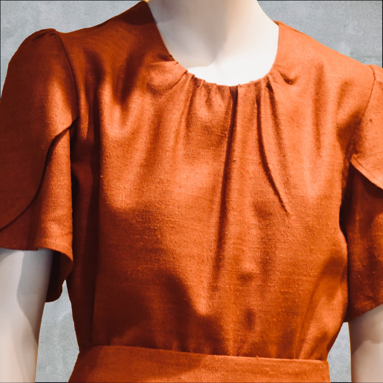 A Tulip Sleeve Blouse in Burnt Brick Silk Matka, featuring textured fabric, short layered tulip sleeves, and gathered detailing at the neckline. Handmade in Britain.