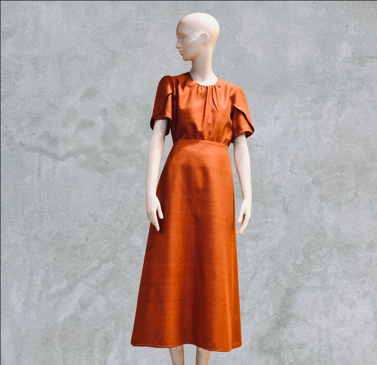 A Simple A-Line Skirt in Burnt Brick Silk Matka, paired with a matching short-sleeve top. The ankle-length skirt features a fitted waist and an elegant silhouette. Handmade in Britain.