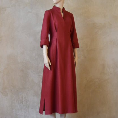 Side Angled shot of Formal silk dress. Handmade in London this pink dress has a nipped in waist, mid length sleeves, turn back cuffs and gently flattering inverted darts at the rear. Slits to the side and an open neckline with a Nehru collar. 
