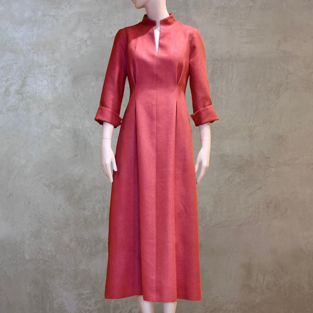 Formal summer dress in pure silk. Handmade in London this pink dress has a nipped in waist, mid length sleeves, turn back cuffs and gently flattering inverted darts at the rear. Slits to the side and an open neckline with a Nehru collar. 