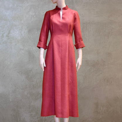 Formal summer dress in pure silk. Handmade in London this pink dress has a nipped in waist, mid length sleeves, turn back cuffs and gently flattering inverted darts at the rear. Slits to the side and an open neckline with a Nehru collar. 