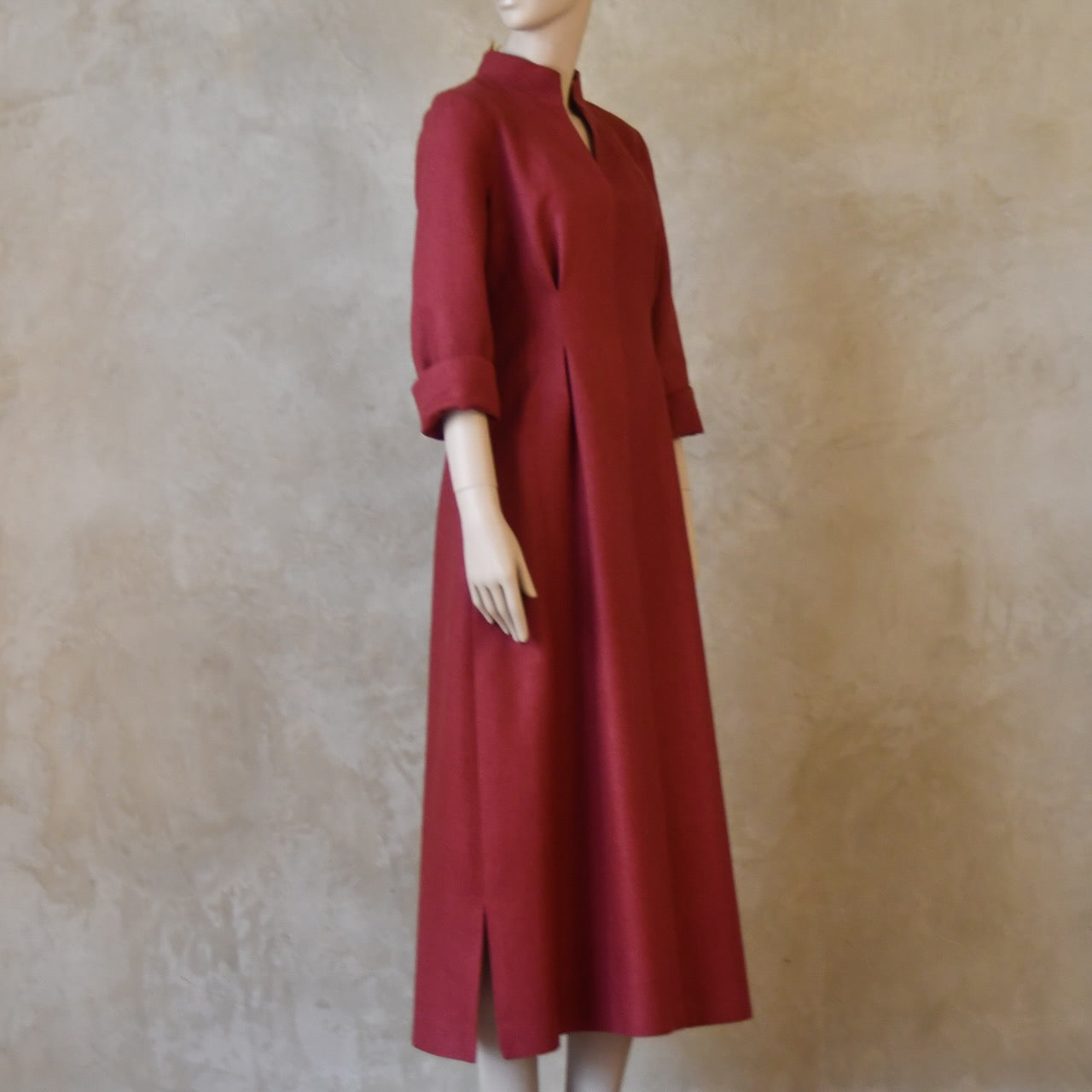 Side shot of Formal silk dress. Handmade in London this pink dress has a nipped in waist, mid length sleeves, turn back cuffs and gently flattering inverted darts at the rear. Slits to the side and an open neckline with a Nehru collar. 