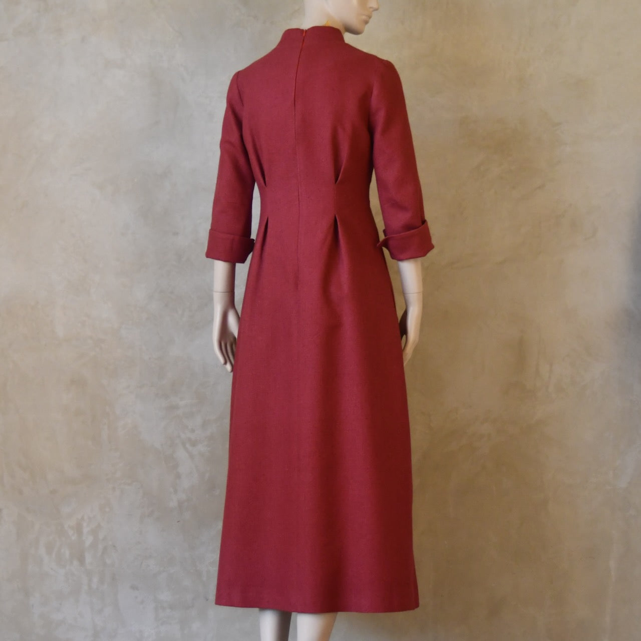 Angled ack view of Dark Pink Silk Waisted longer length mid-season tailored dress. Ready to Ship and Made to order. Sizes 6 to 20 and bespoke. Made by hand in East London.