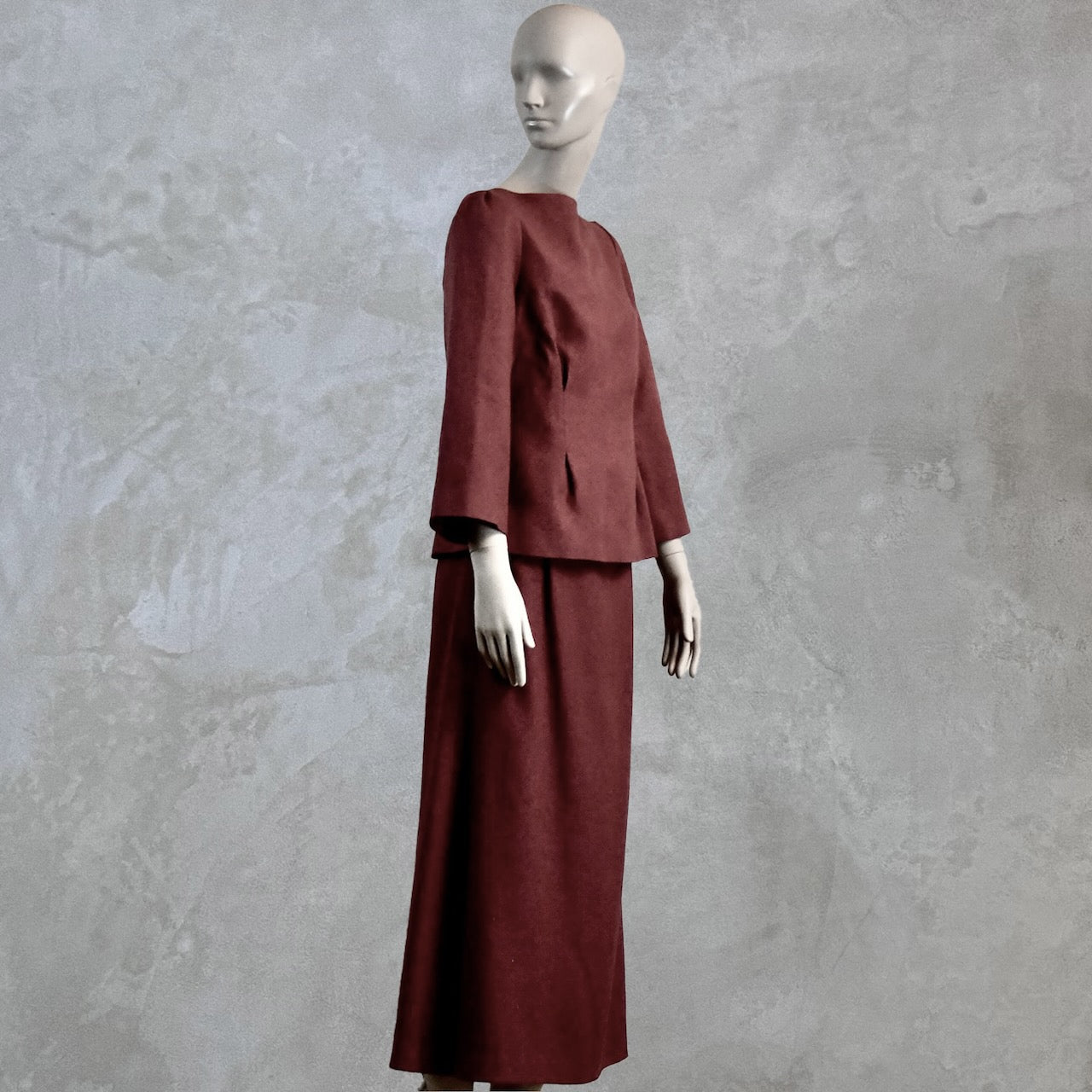 A Tailored Boat Neck Skirt Suit in Damson Silk Matka, featuring a fitted long-sleeve top and matching skirt. Handmade in Britain. Side View.