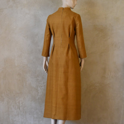 Rear view of Tan coloured tailored formal wear silk dress. Three quarter length sleeves, fully lined in silk with gathering darts at front and rear creating flattering hourglass shape. Handmade in London.