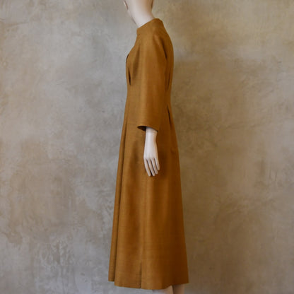 Side shot of Tan coloured tailored formal wear silk dress. Three quarter length sleeves, fully lined in silk with gathering darts at front and rear creating flattering hourglass shape. Handmade in London.